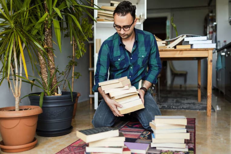 man cleaning out books