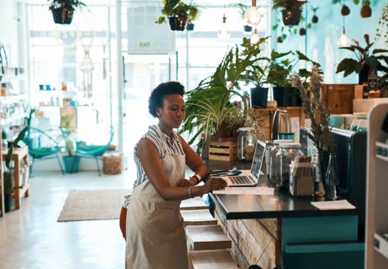 Store owner in boutique looking at laptop