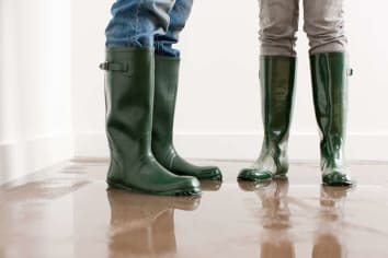 people standing in flooded house with rain boots