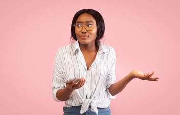 woman shrugging shoulders at smartphone