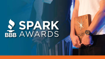 Spark Award winner holding their award on stage